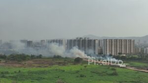 PD0125 - Smoke from a Fire Billowing Towards an Urban Cityscape in India