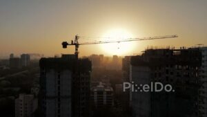 PD0132 - Aerial View of a Construction Site Crane Silhouetted Against a Hazy Sunset