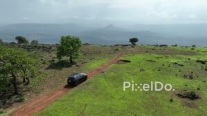 PD0117 - Aerial View of SUV Parked at a Scenic Cliffside Viewpoint in the Mountains