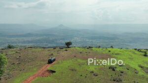 PD0116 - Aerial Shot of SUV Reaching a Scenic Mountaintop Viewpoint in India