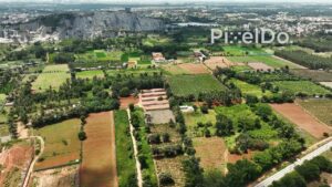PD0174 - Aerial View of a Large Stone Quarry Bordering Green Agricultural Land in India
