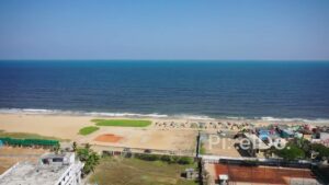 PD0218 - Aerial Reveal Shot of a Chennai Beach with Fishing Boats and a Coastal Town