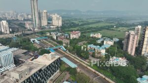 PD0052 - Aerial View of Mumbai's Suburban Railway Line Bordering a Vast Green Landscape