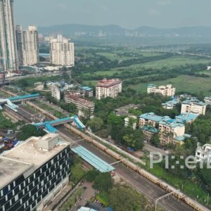 PD0052 - Aerial View of Mumbai's Suburban Railway Line Bordering a Vast Green Landscape