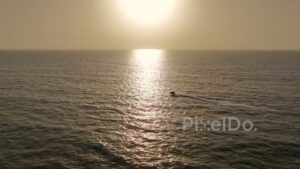 PD0492 - Boat Sailing into a Golden Sunset Over the Ocean