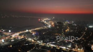 PD0482 - Mumbai City Lights: Aerial Pan of Bandra Coastline at Dusk