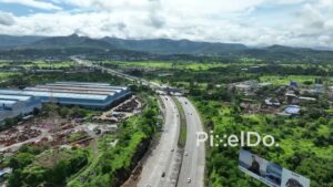 PD0757 - Aerial View of Expressway Flanked by Industry and Mountains