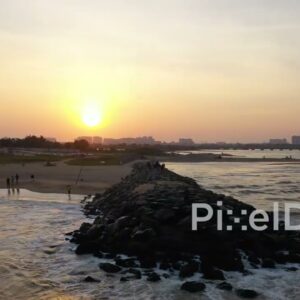 PD0899 - Aerial Orbit of a Man on a Jetty During a Golden Sunset