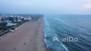 PD0916 - Aerial Flight Along a Serene Urban Beach at Dusk