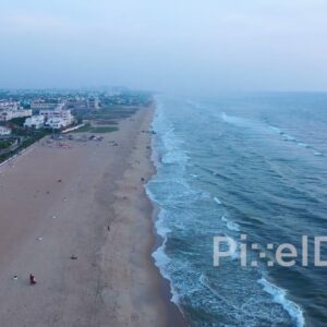PD0916 - Aerial Flight Along a Serene Urban Beach at Dusk