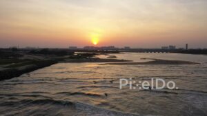 PD0906 - Panoramic Aerial of a Beach and Surfers at Sunset