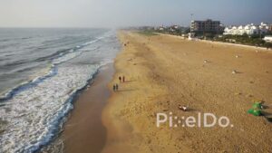 PD0944 - Drone Follows People Walking on a Scenic Urban Beach