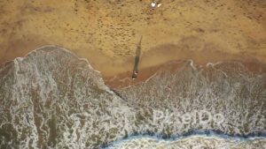 PD0941 - Top-Down Drone View of Couple Walking Along the Shoreline