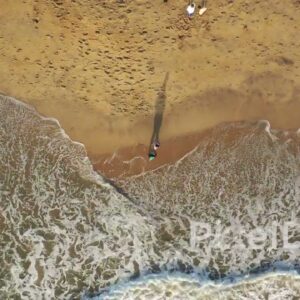 PD0941 - Top-Down Drone View of Couple Walking Along the Shoreline