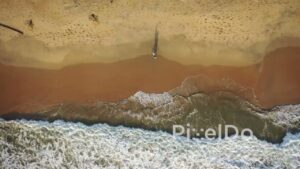 PD0940 - Top-Down Drone View of Couple Walking by the Ocean's Edge