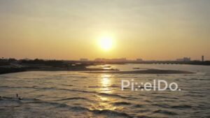 PD0981 - Scenic Drone Pan of Surfers at Golden Sunset