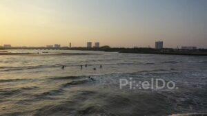 PD0979 - Aerial Drone Orbits Surfers at Golden Hour Sunset