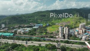 PD0997 - Aerial Pan of Navi Mumbai's Belpada Metro Station and Highway Traffic