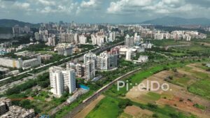 PD0996 - Aerial Pan Following a Commuter Train Through the Suburban Landscape of Kharghar