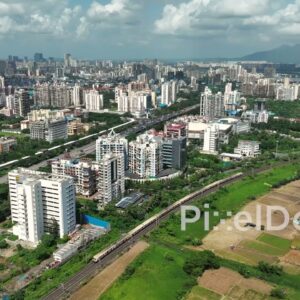 PD0996 - Aerial Pan Following a Commuter Train Through the Suburban Landscape of Kharghar