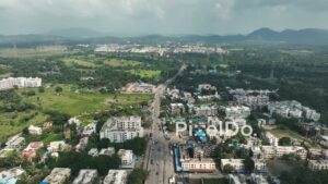 PD1067 - Aerial Drone Flight Over a Busy Suburban Town Road and Mountain Landscape