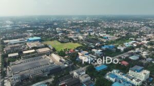 PD1064 - Aerial Drone Flight Over Industrial Estate with Solar Panels and Cityscape
