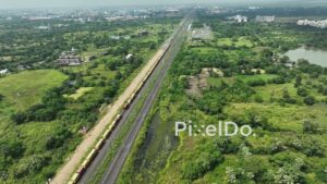 PD1061 - Aerial Drone Flight Over a Long Freight Train on a Suburban Corridor