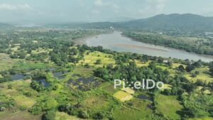 PD1021 - Aerial Flight Over Lush River Valley and Mountain Landscape