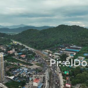 PD1092 - Aerial Drone View of Urban Sprawl and Highway at Forested Mountain Base