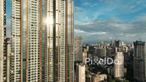 PD1123 - Aerial Drone Rise Alongside Modern Glass Skyscraper in Dense Cityscape