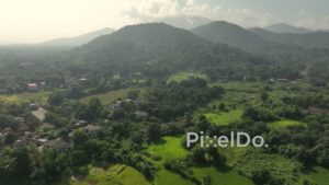 PD1017 - Aerial Flight Over Green Valley Village Towards Mountains
