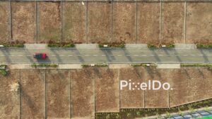 PD1161 - Top-Down Aerial Drone Tracking Red Car in New Land Plot Development
