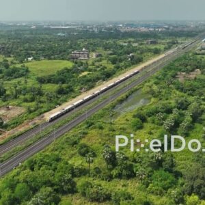 PD1055 - Aerial Drone Flight Following Commuter Train Through Green Landscape