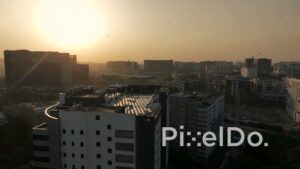 PD1385 - Aerial View of Rooftop Solar Panels and Urban Skyline at Sunset