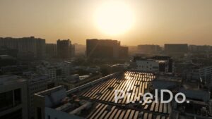 PD1384 - Aerial View of Rooftop Solar Panels and City Skyline at Golden Sunset