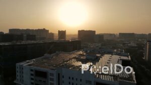 PD1383 - Aerial View of Rooftop Solar Panels and Corporate Skyline at Sunset